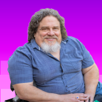 Jim LeBrecht axe-con 2025 keynote speaker: a white man in 60s with goatee who is a wheelchair user
