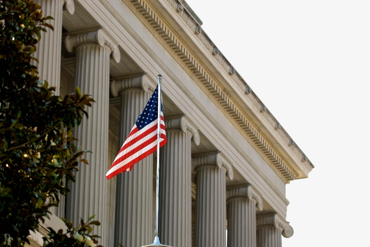 long angle view of a government building with American flag in front, meant to represent section 508 refresh briefing.