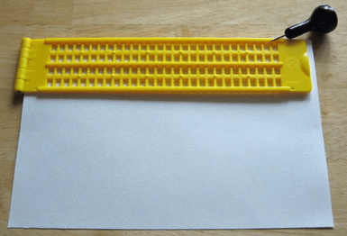 Photo illustrating the described placement of the index card in the closed Braille Slate.