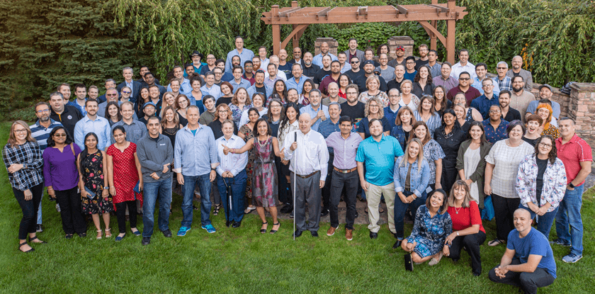 Various Deque employees posing and smiling together in a group photo.