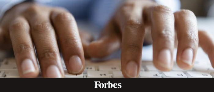 Hands at a keyboard, with the Forbes logo