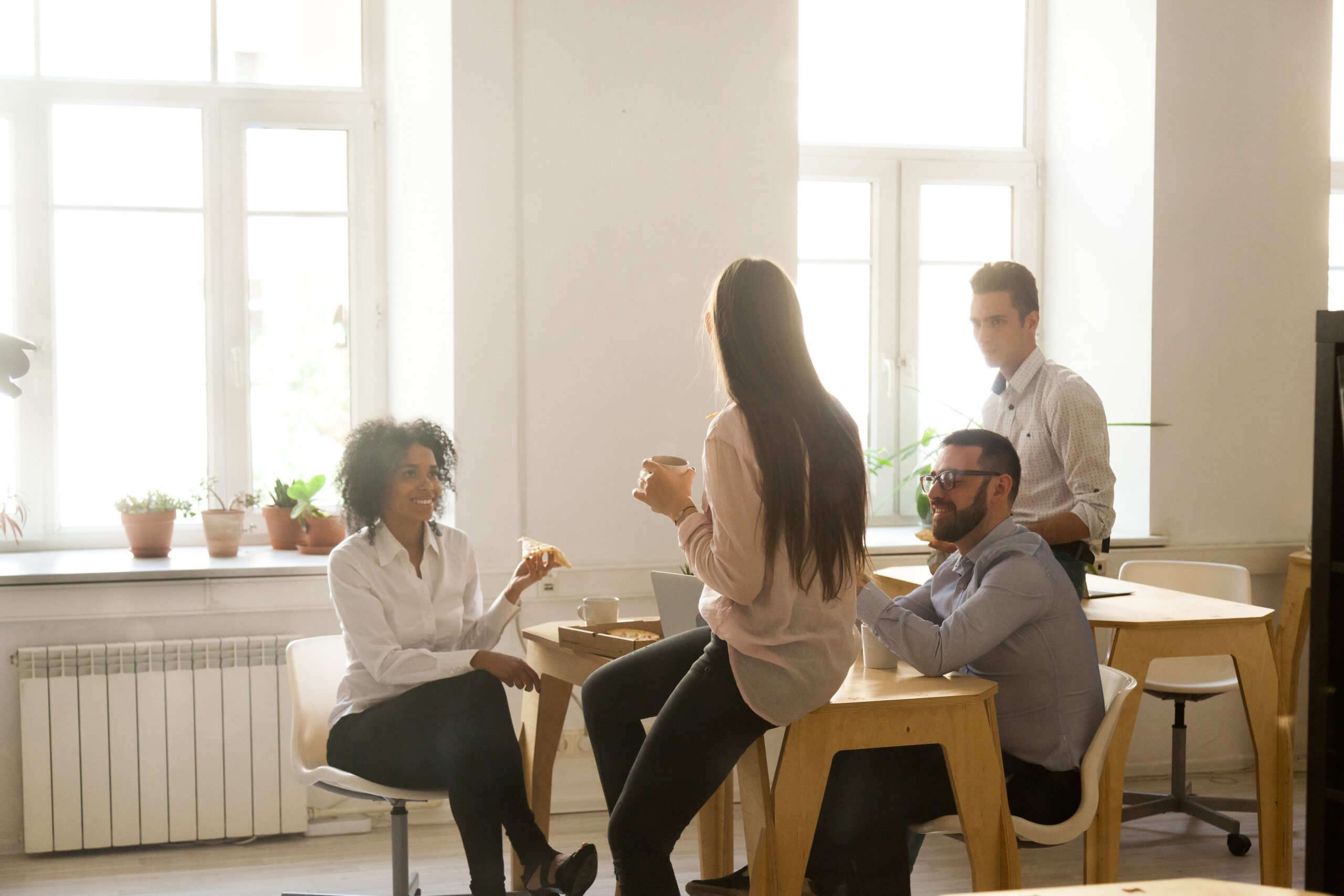 group of people socializing at an office break room table