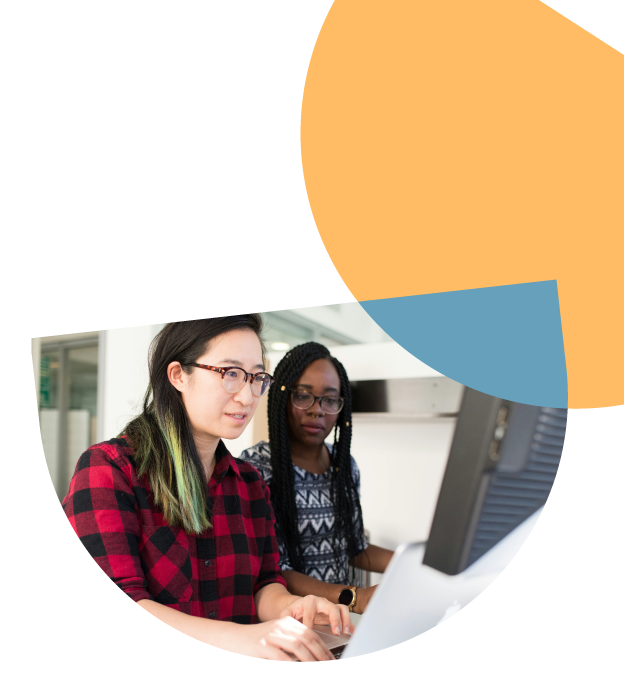 Two women wearing glasses looking at a computer screen
