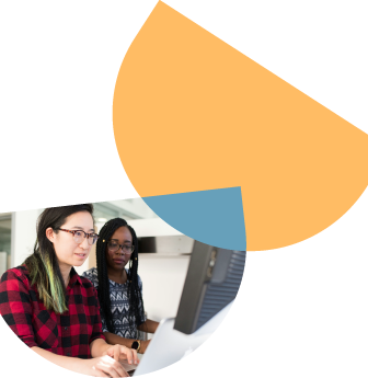 two women wearing glasses looking at a computer screen