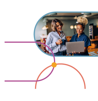 Two colleagues huddled over a laptop and smiling