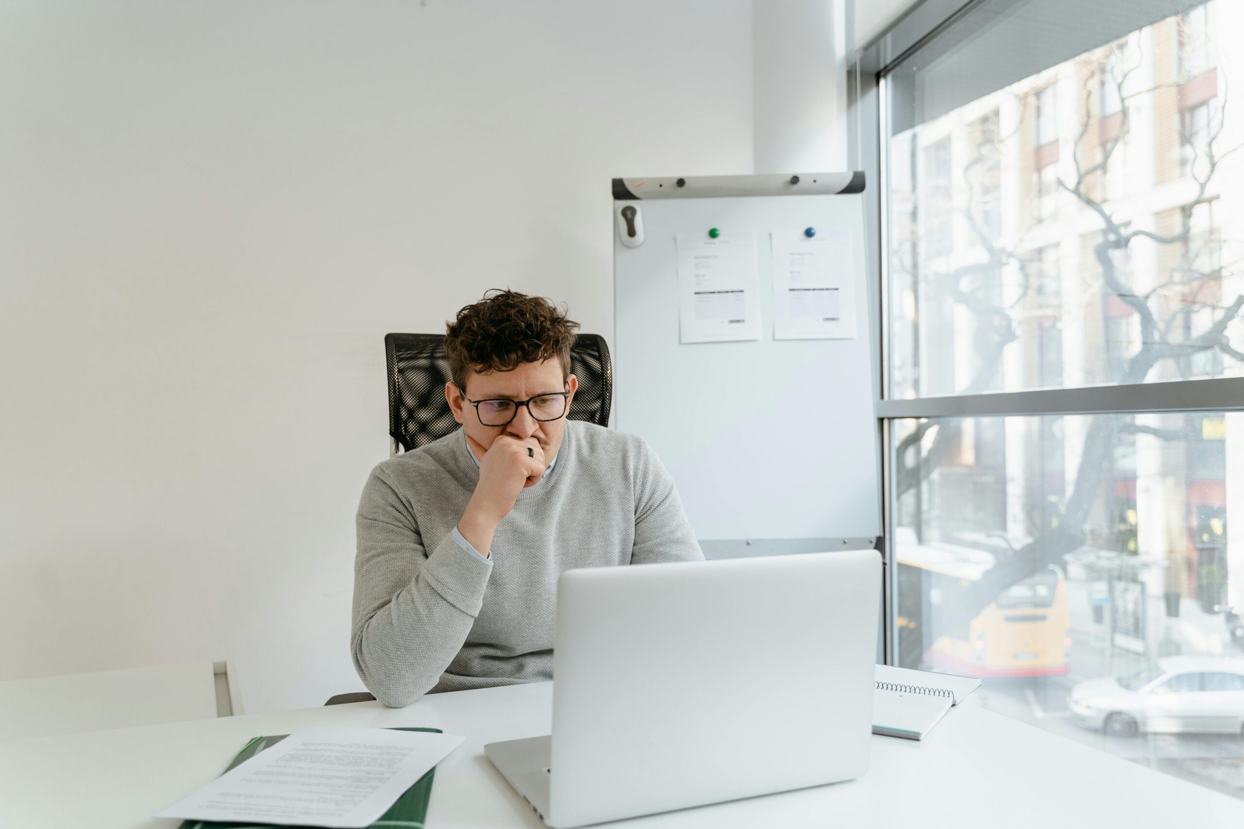 man with glasses sitting at a laptop