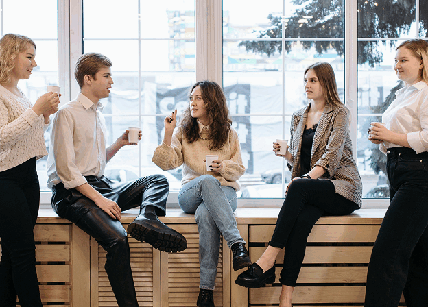 Group of young professionals sitting and standing while chatting together