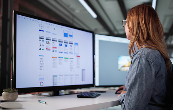 A Designer entranced at work in front of two large displays
