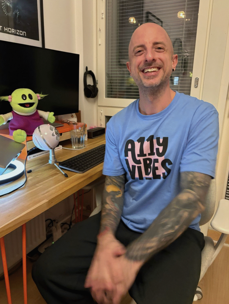 Daniel Yuschick wearing his light-blue A11y Vibes t-shirt from Axe-con.