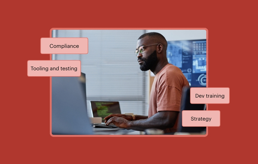 An Engineering Leader working at their desk. Text bubble surround the image that read Compliance, Tooling and testing, Dev training, and Strategy.