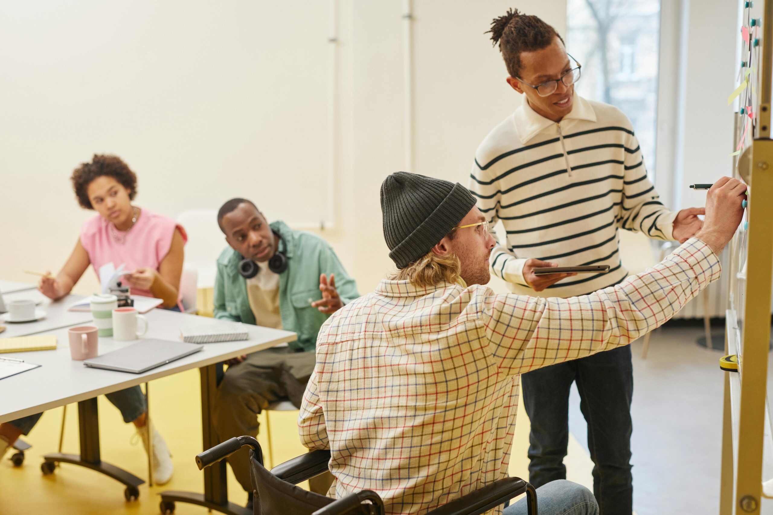 Diverse team working together in a meeting, reviewing notes on a board