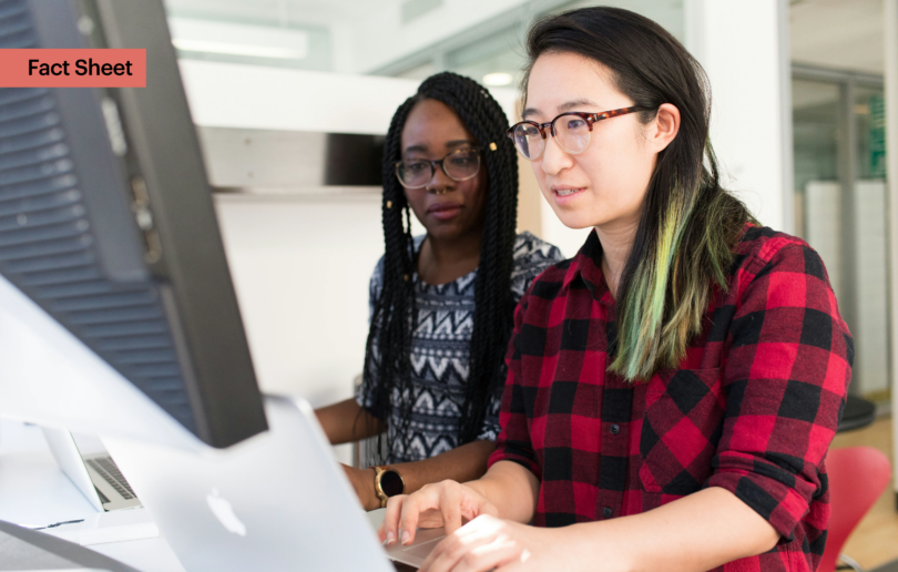 Two colleagues working together over a keyboard